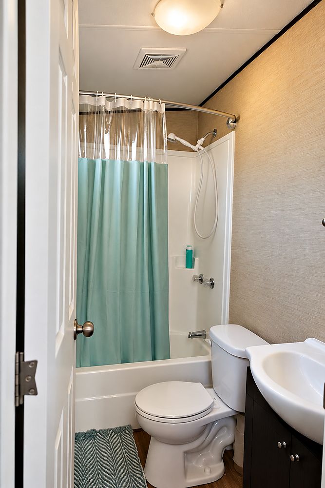 The Peacedale Cottage bathroom with a full bath and shower, toilet and vanity