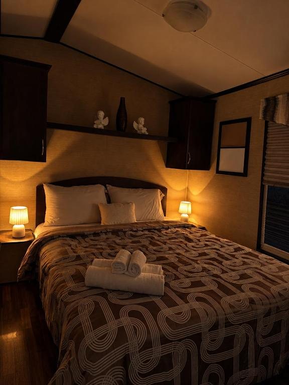The Peacedale Cottage bedroom with a double bed, bedside lamps lit and fresh towels laid out