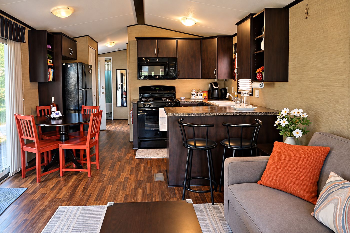 The open-plan interior of Peacedale Cottage, looking from the sofa past the breakfast bar to the kitchen and dining table